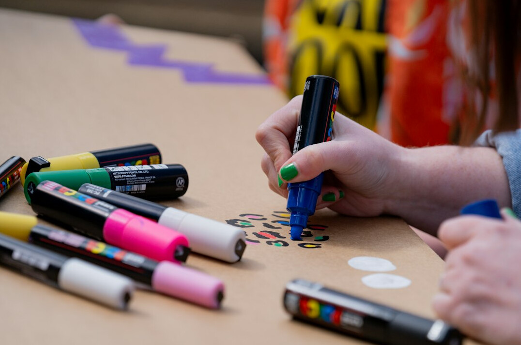 Hands writing on sticky notes during a workshop session
